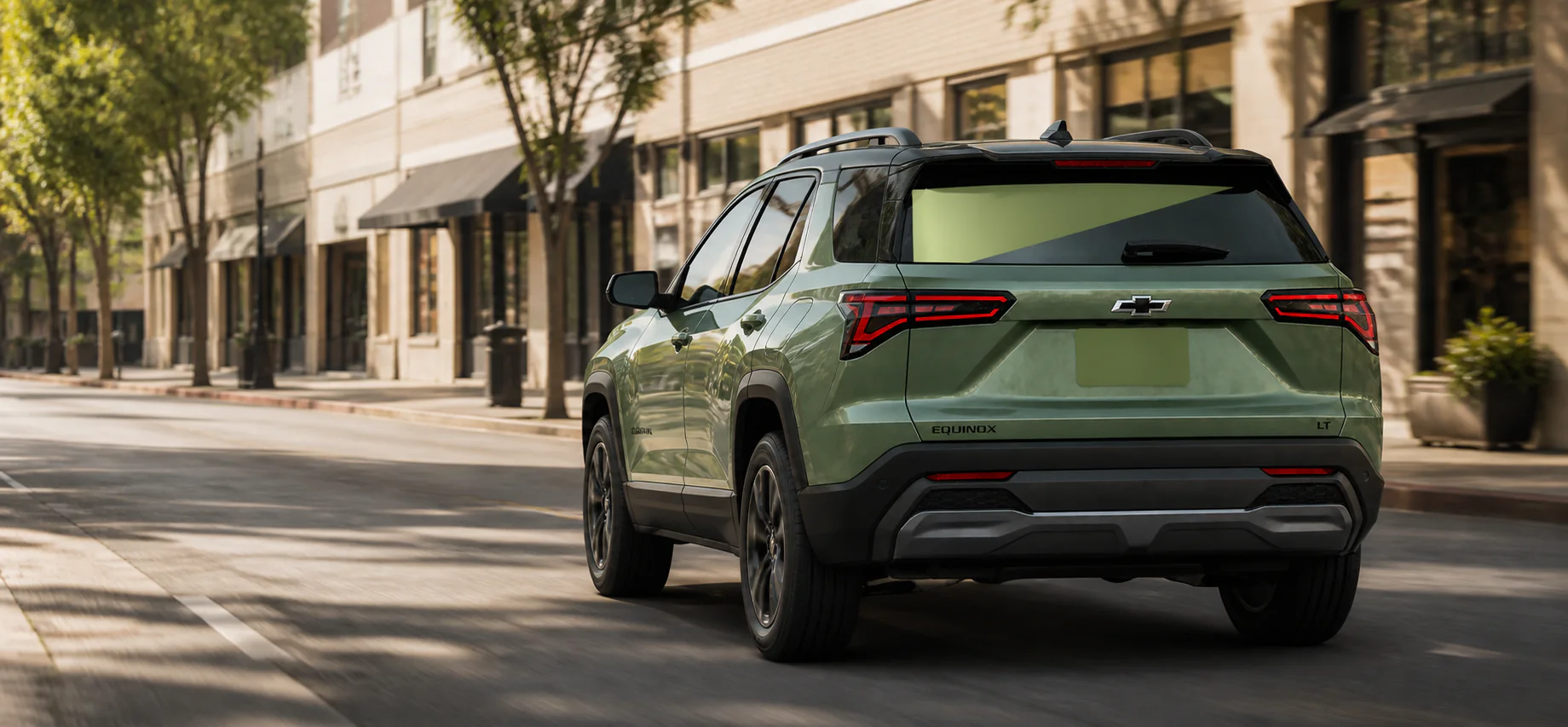 Olive green Chevrolet Equinox carrying blank advertising vinyl while driving through a commercial district